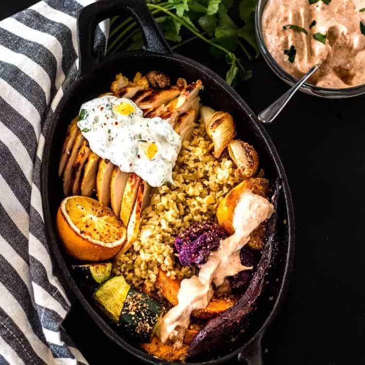 North African Grilled Chicken and Roasted Veggie Bowls - Chicken and Veggie Bowl plated for serving with a black and white napkin.