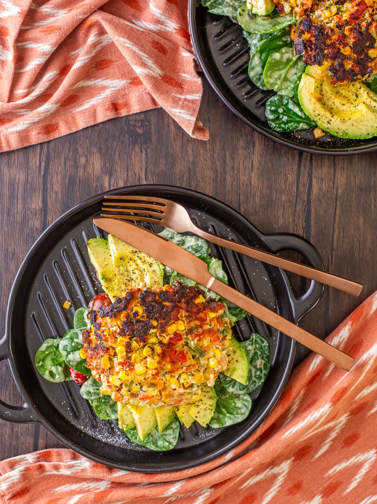 Spicy Mexican Salmon Patties with Creamy Cilantro Ranch and Spinach Salad - 3 salmon patties on a square grill with avocado, lime, and salad.