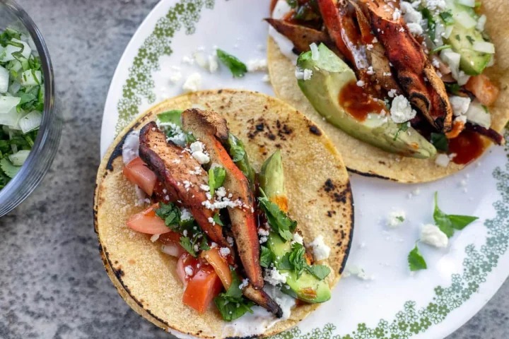 Chicken of the woods tacos on a white plate.