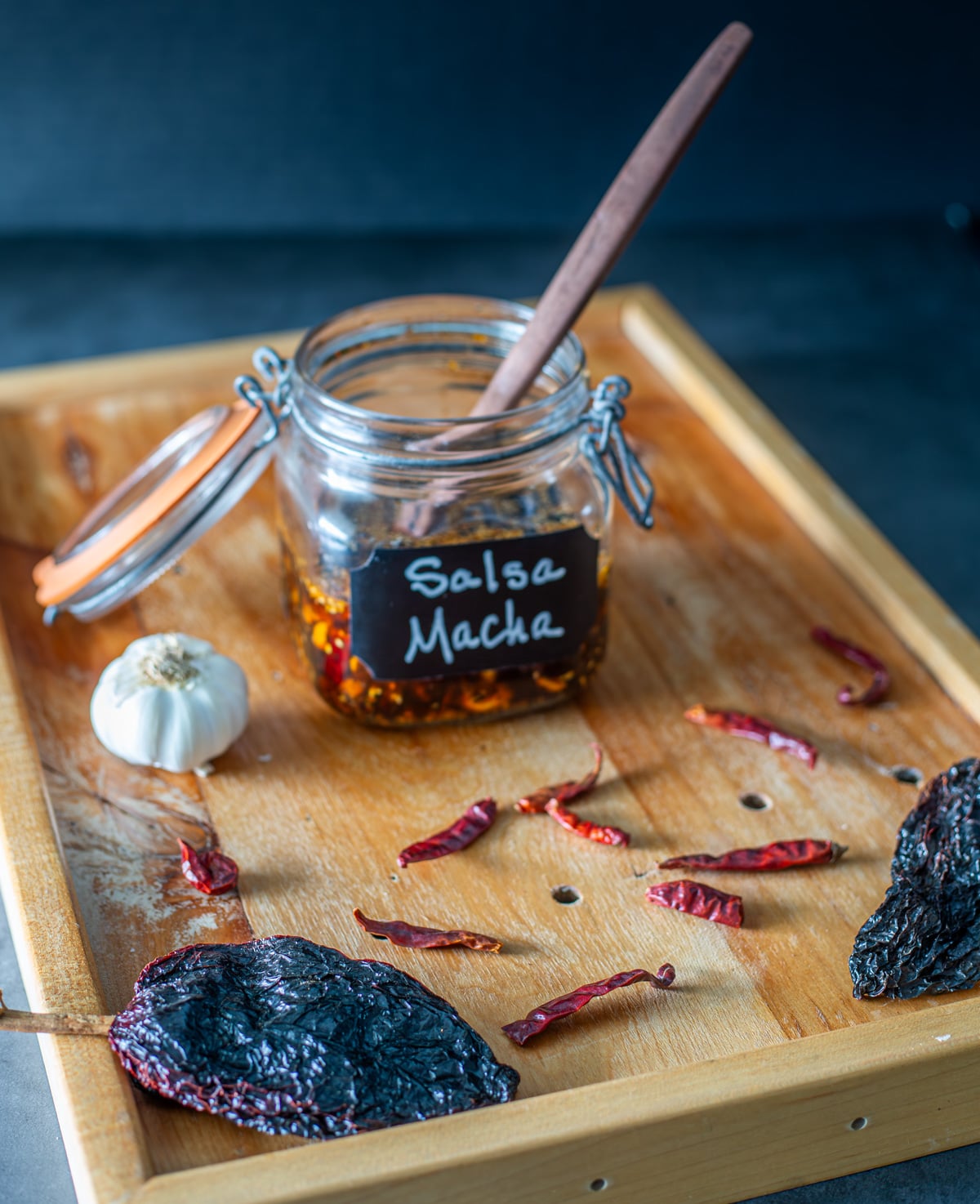 A glass jar with chipotle pepita salsa with striped napkin and veggies in the background.