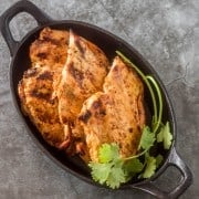 Grilled Tajín Chicken in a cast iron skillet with cilantro.