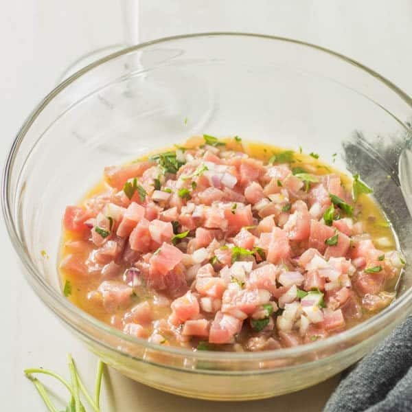 A glass bowl with the prepared ahi tuna tartare.