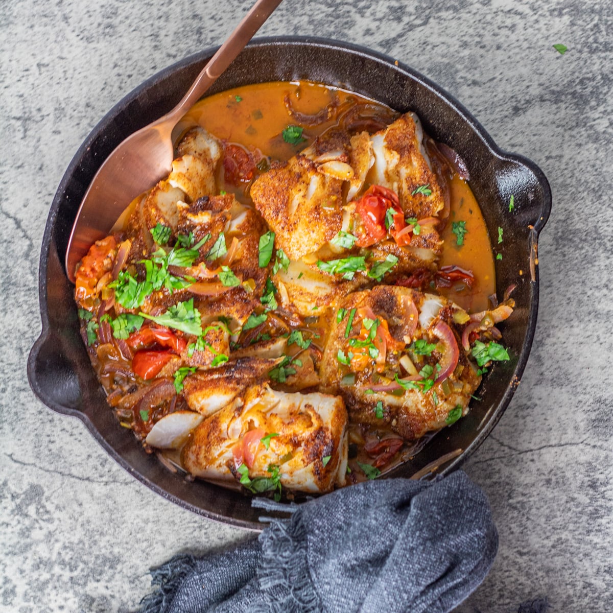 A cast iron skillet with 4 pan seared Mexican fish portions.