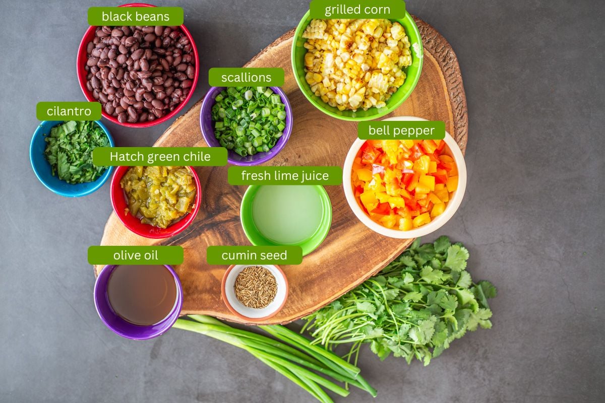 Ingredients for Hatch chile, black bean, and corn salad on a wood cutting board.