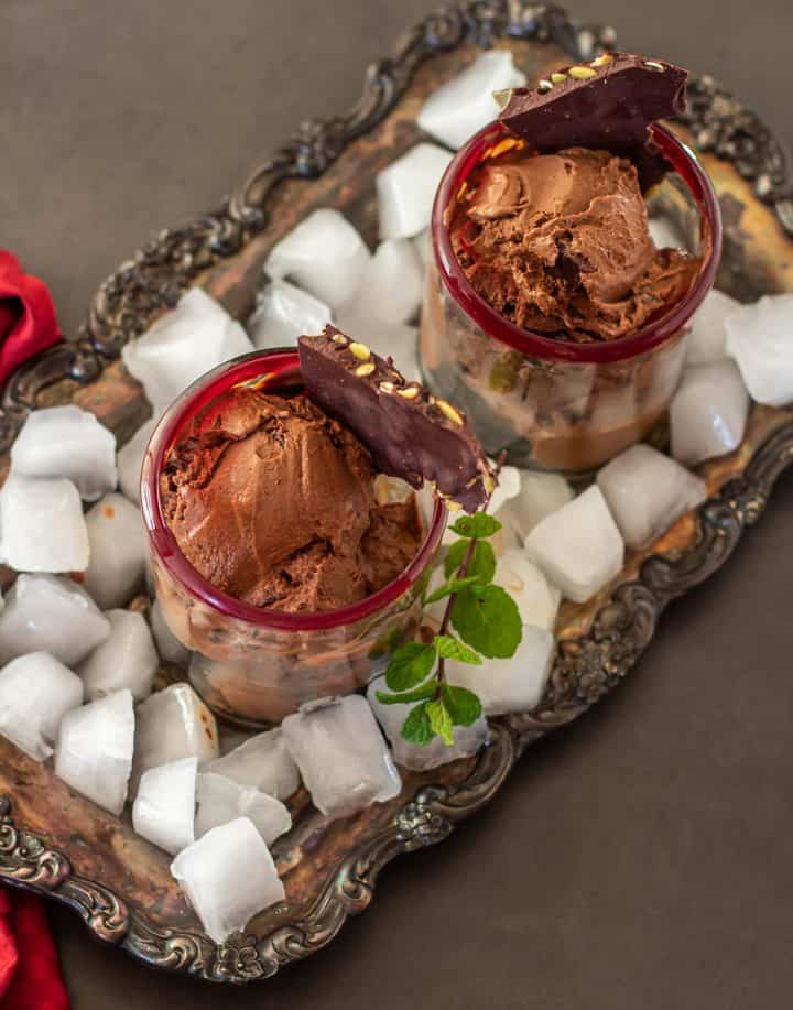 2 scoops of Mexican chocolate ice cream in red-rimmed glasses on ice.
