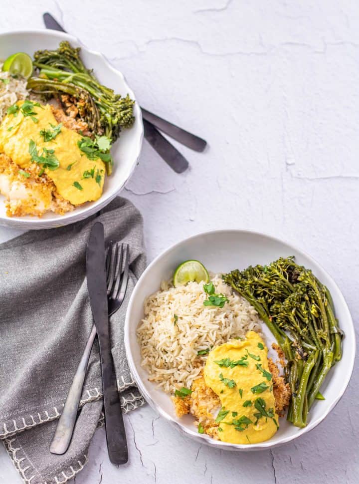 Baked Peruvian cod topped with huancaína sauce, Peruvian rice, and green veggies.