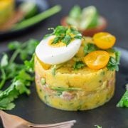 A close up of a single Peruvian cause on a black stoneware plate.