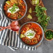 A black stoneware bowl of Peruvian beef stew with salsa criolla.