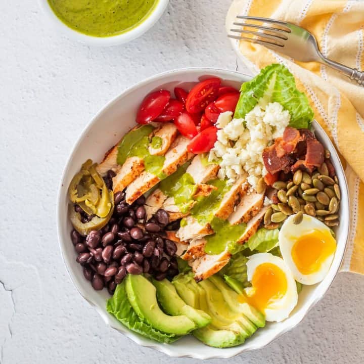 A white ceramic bowl of Mexican cobb salad with cilantro-lime dressing.
