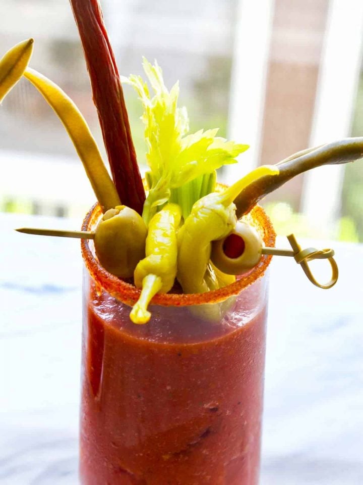 A tall glass with Hatch green chile bloody mary mix and garnishes.