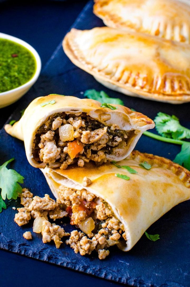 Hatch green chile and pork empanadas on a blue background.