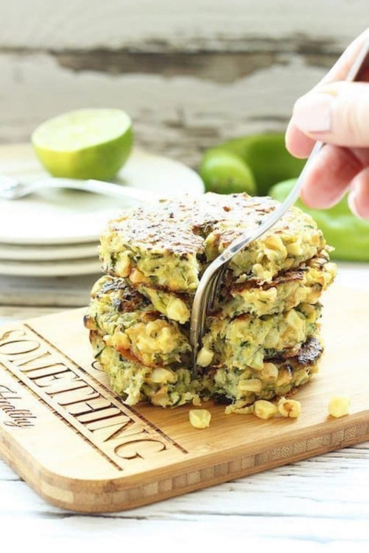 Healthy zucchini fritters with Hatch green chile on a wood cutting board.