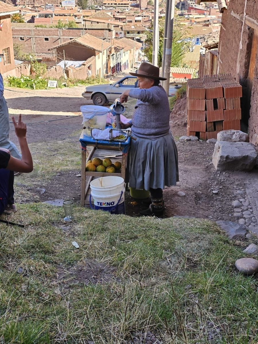 A Quechua lady squeezing orange juice at the foot of the trail to the Pisac Ruins.