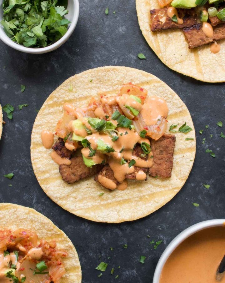 Fusion kimchi tacos with cod in a baking pan with toppings.