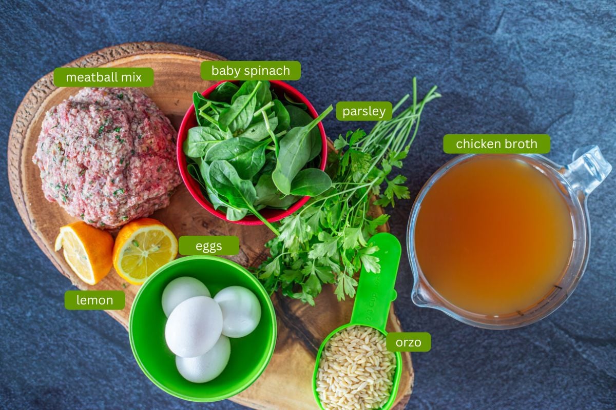 Greek meatball soup ingredients - meatball mix, eggs, spinach, broth, orzo, and lemon.