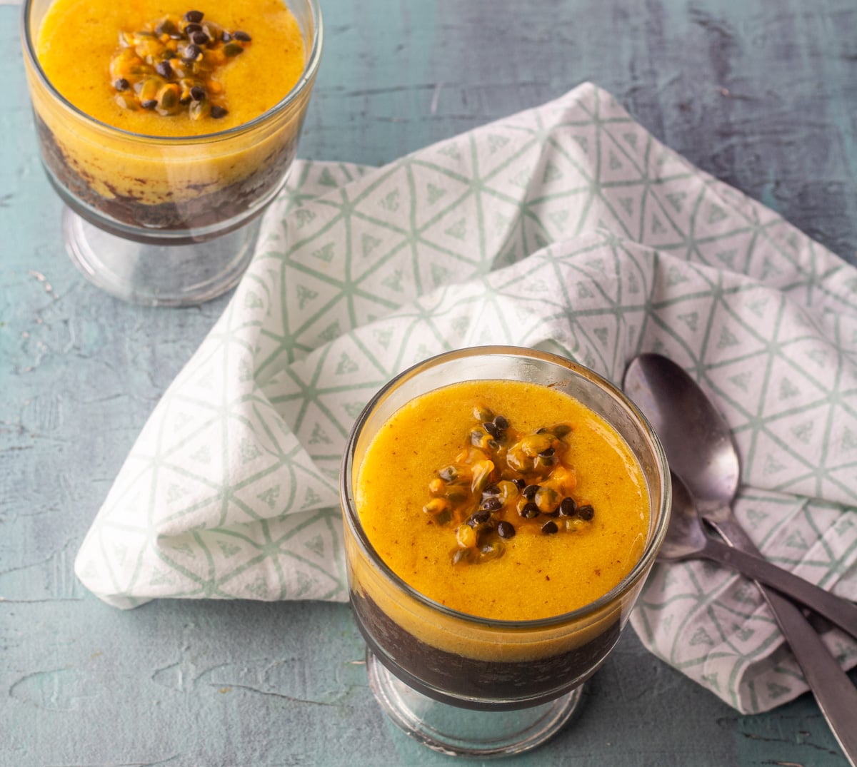 A close up of passionfruit dark chocolate flourless cake with a light-colored napkin.