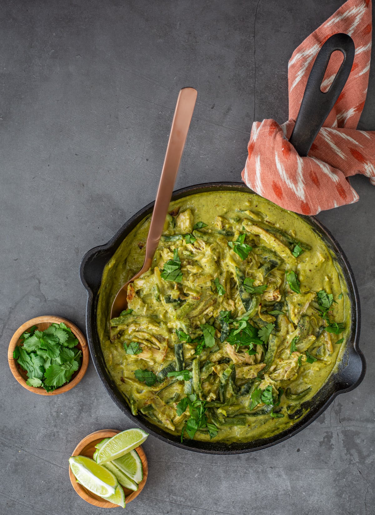A cast iron skillet with creamy poblano chicken, print napkin.