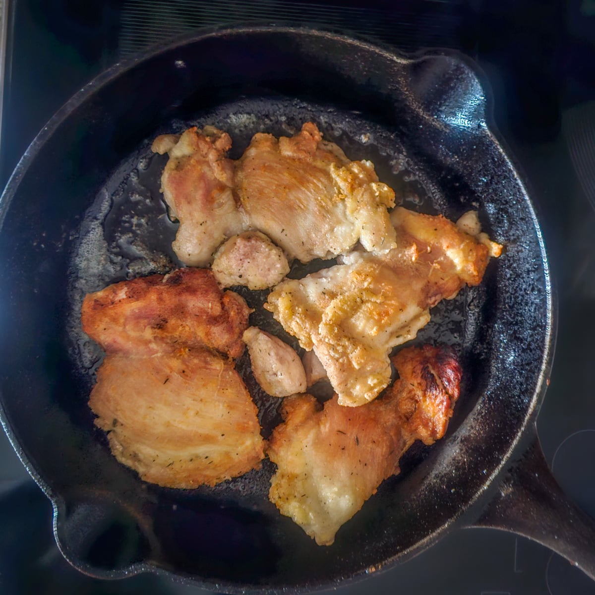 Step 2 - Seasoned chicken is browned in a cast iron skillet.