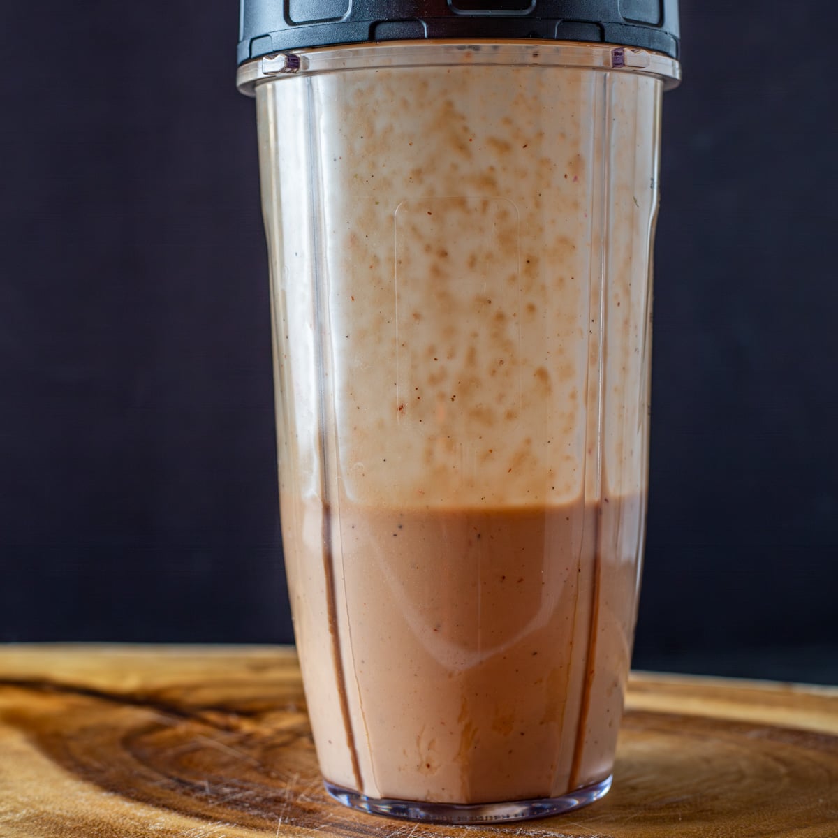 The blender cup with the pomegranate vinaigrette after it is emulsified.