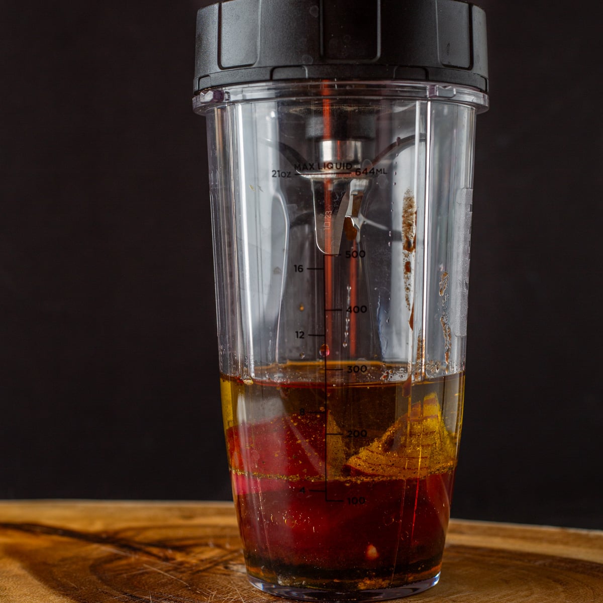 A blender cup with the pomegranate vinaigrette ingredients before blending.