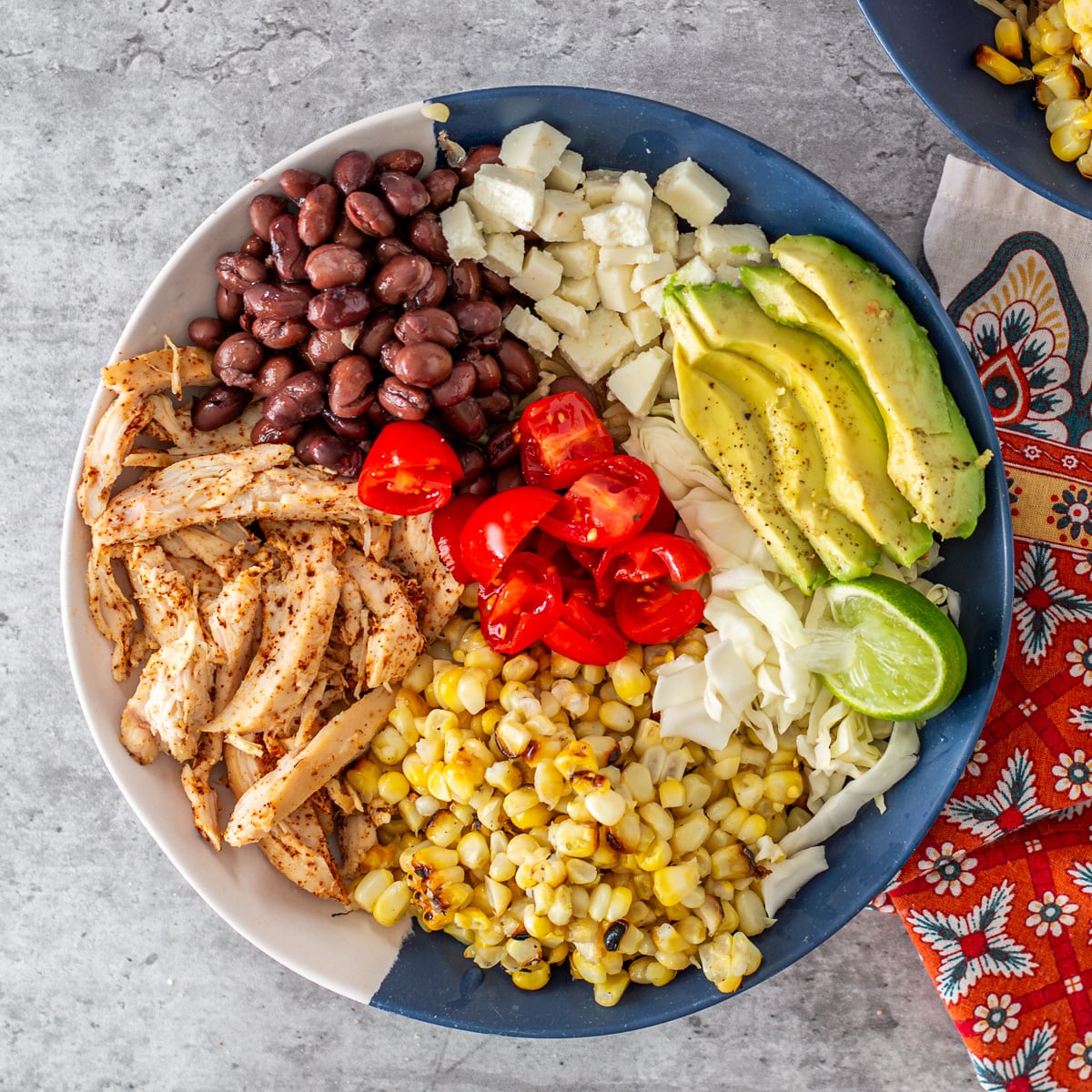 Step 2 - Add tomatoes, avocado, lime wedges, etc. to the bowl.