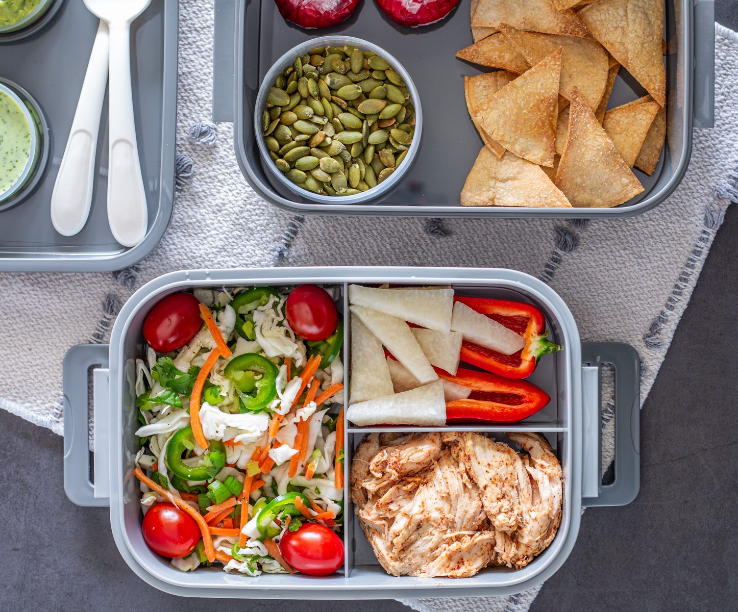 A close up of the finished bento box with slaw, taj&iacute;n chicken, and veggies.