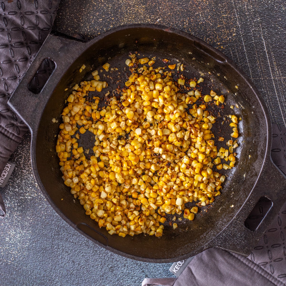 Step 1 - Fresh corn off the cob is charred in a cast iron skillet.