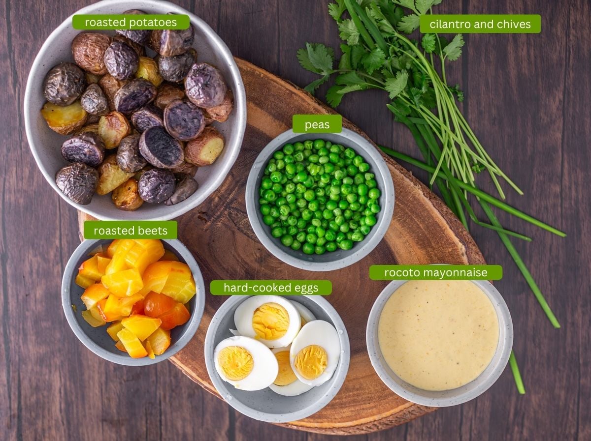 Ingredients for Peruvian potato salad with beets including purple and red potatoes, golden beets, peas, and hard-cooked eggs.