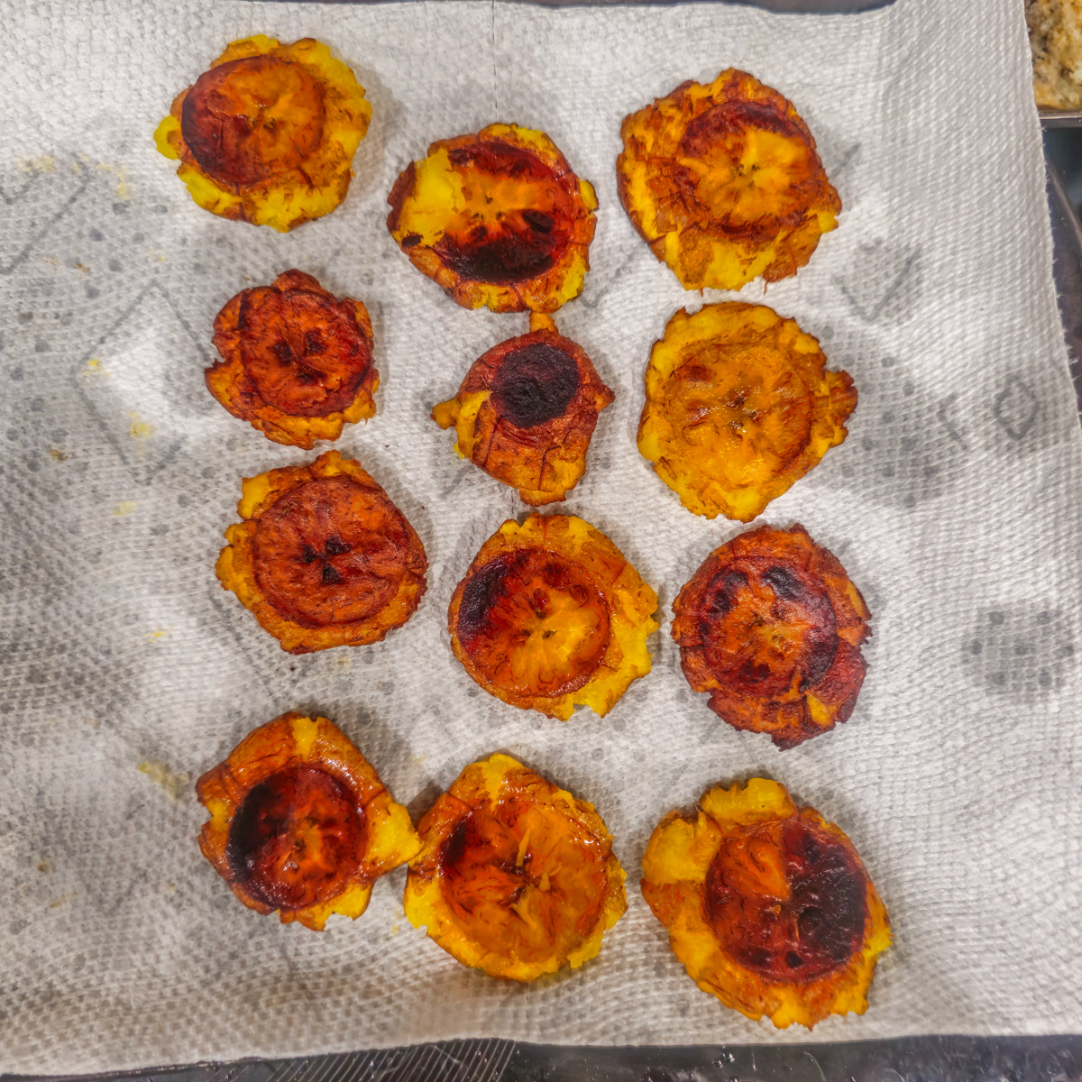 The fried tostones on paper towels after frying to remove grease.