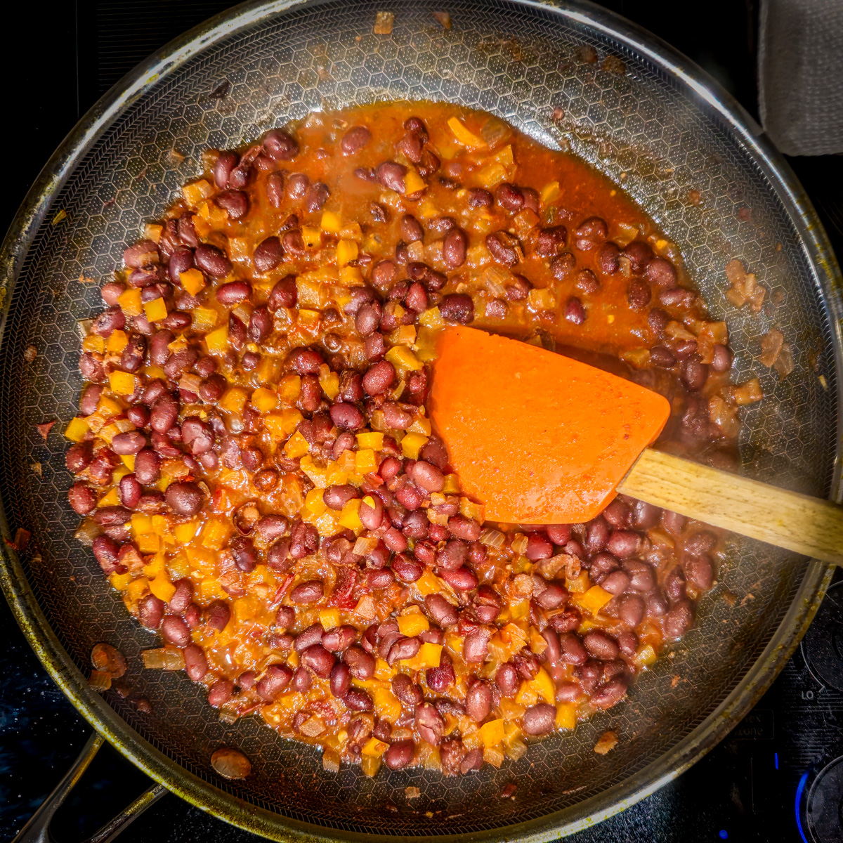 The black beans, broth, and citrus juice are added to the skillet.