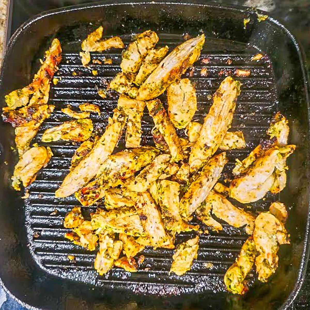 The chimichurri marinated chicken breast is seared on a hot cast iron griddle.