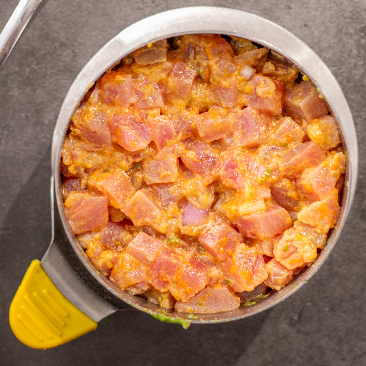 Citrus-marinated tuna is pressed into the ring mold.