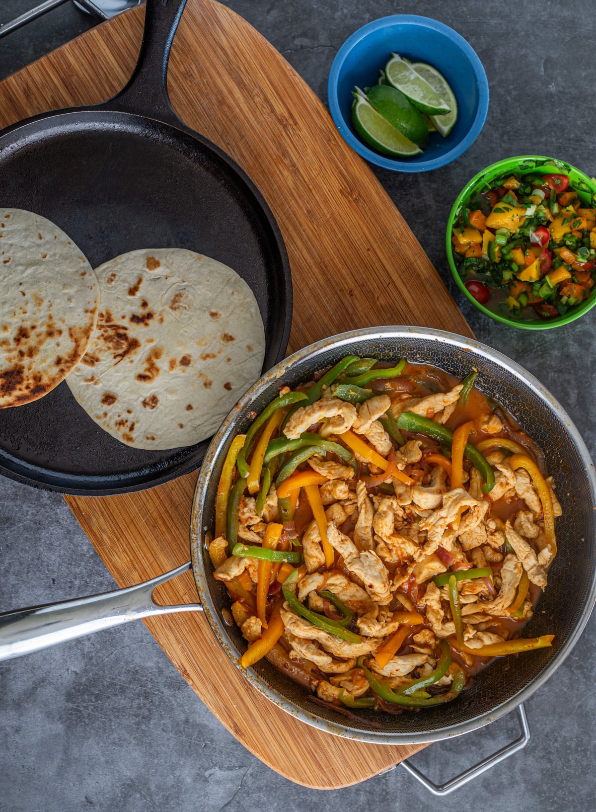 The Thai chicken curry is in a saut&eacute; pan alongside a comal with flour tortillas and mango salsa.