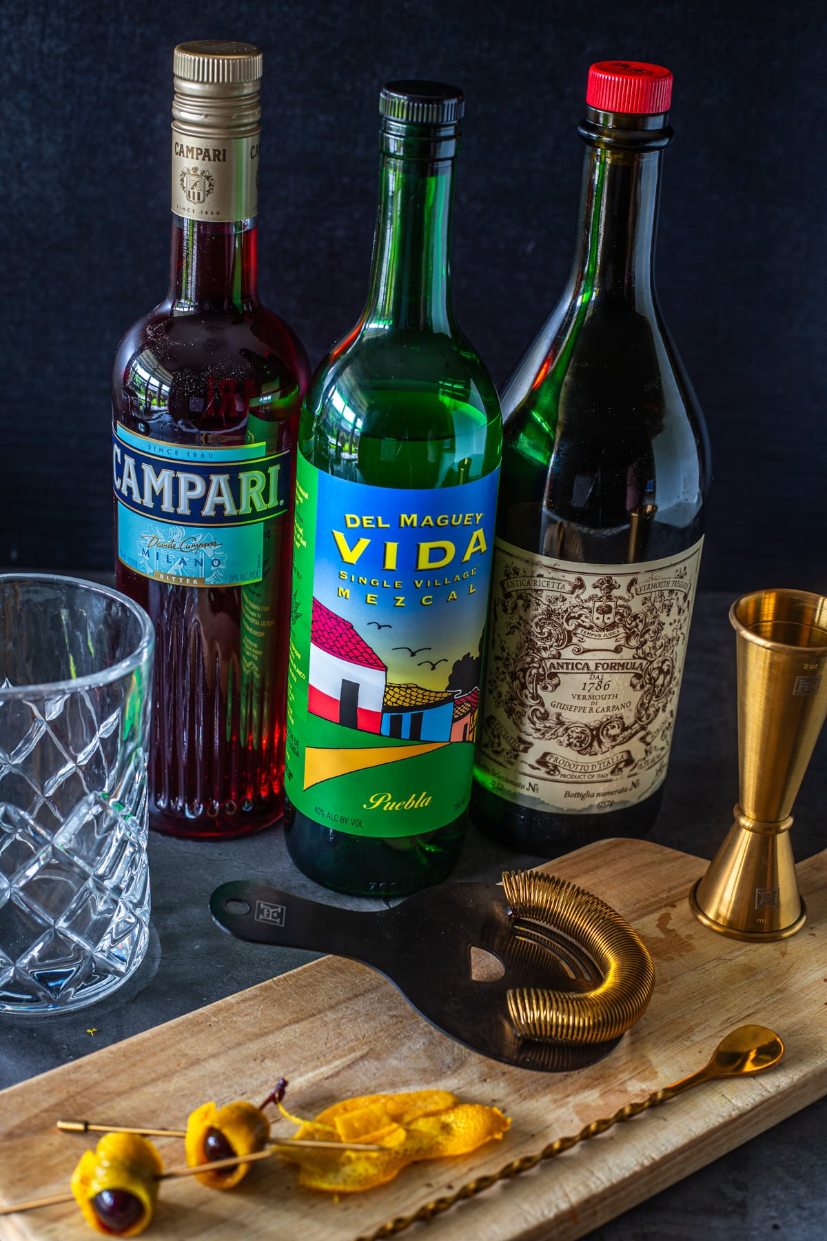 Ingredients for mezcal negroni cocktails: Campari, Mezcal, and sweet vermouth.