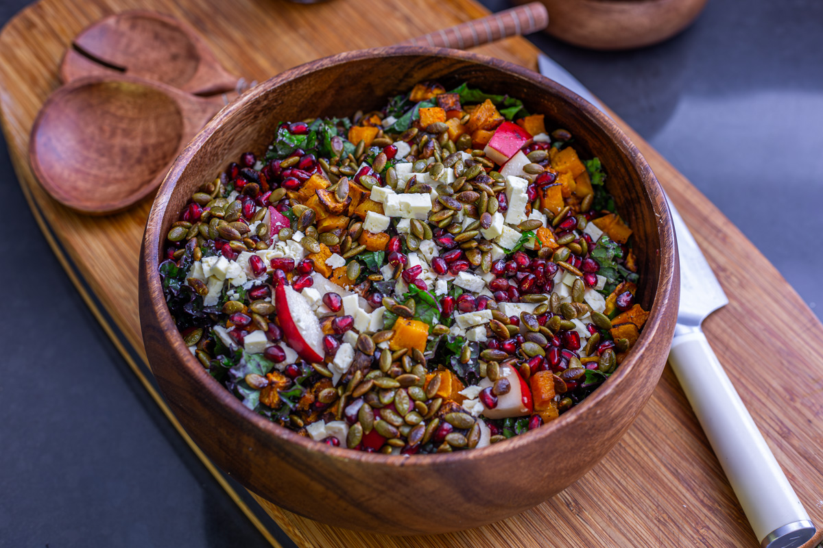 A close up of the fall kale salad with all ingredients and dressing added (before tossing).