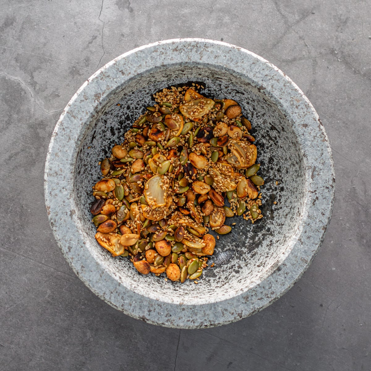 A molcajete with the toasted and fried nuts and seeds.