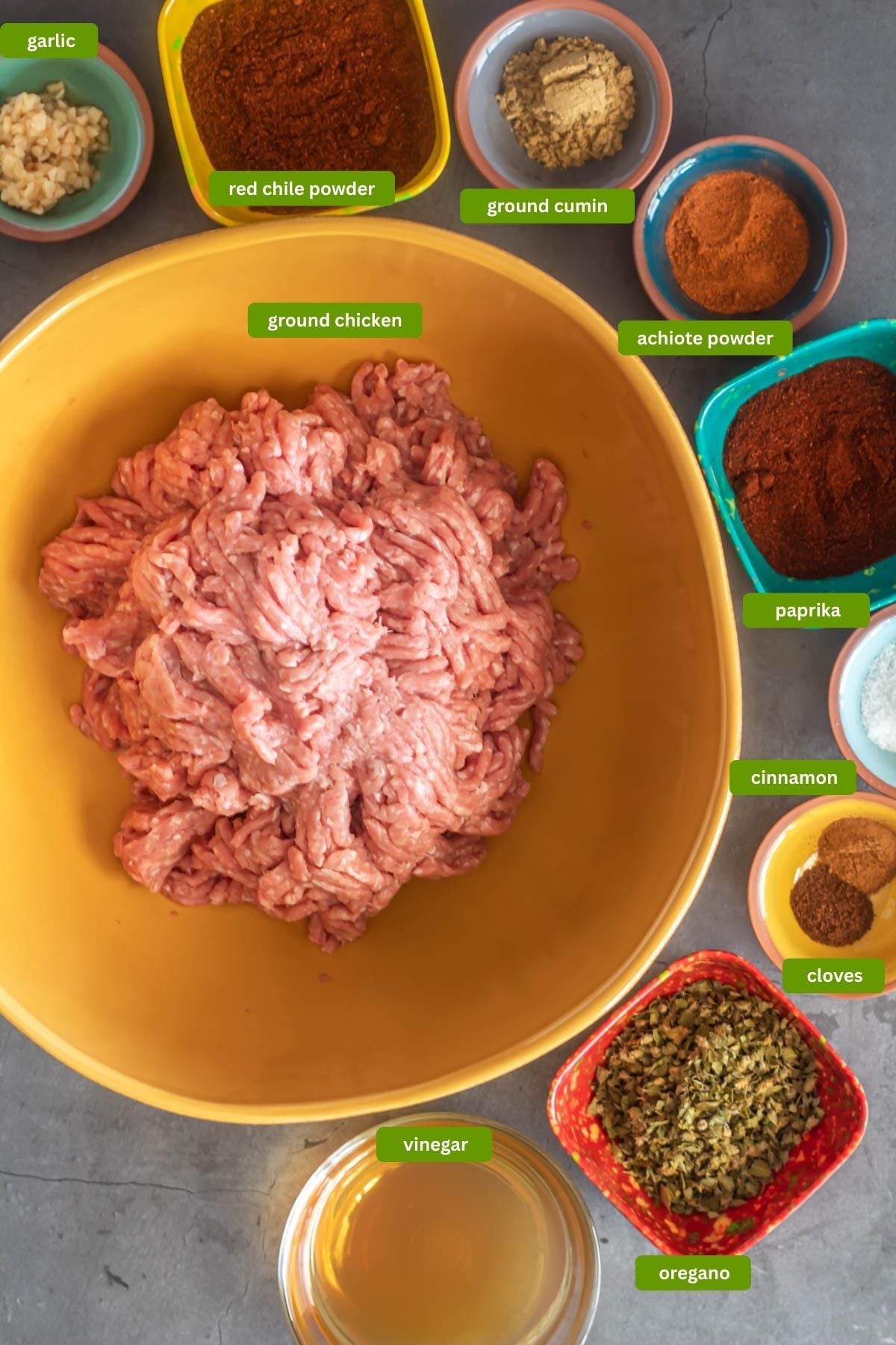 All of the ingredients for healthy homemade chorizo sausage ready to be added to the ground chicken - garlic, red chile powder, salt, spices, Mexican oregano, vinegar.