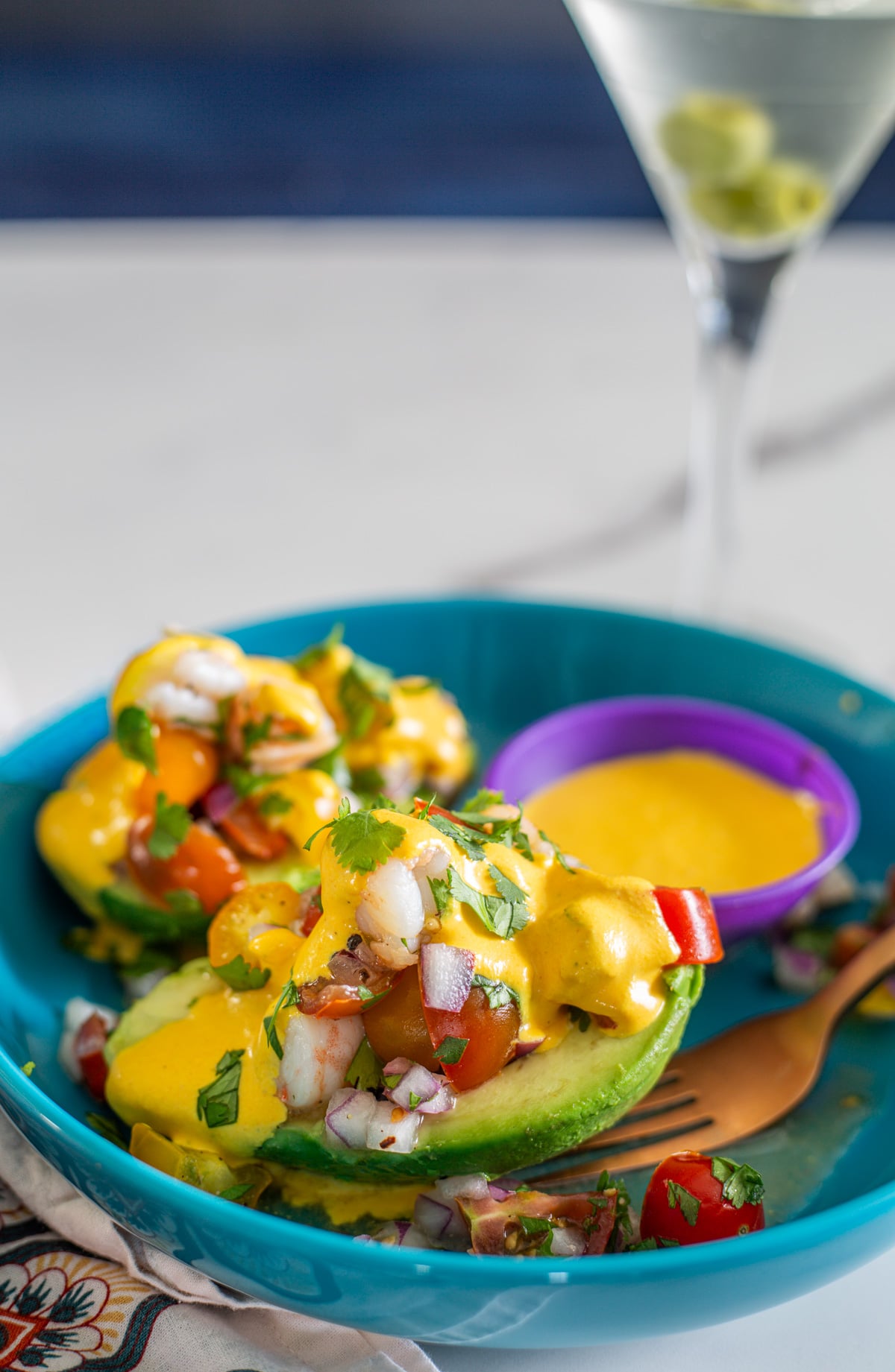 A shallow turquoise bowl 2 2 palta rellena con camarones halves, and a