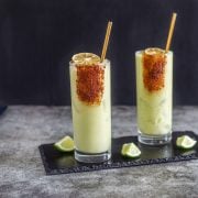 A slate tray with 2 spicy smoky coconut avocado margaritas.