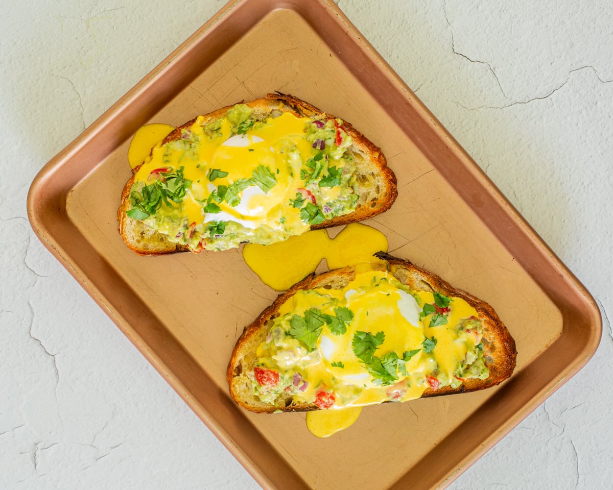 A copper sheet pan with 2 Peruvian eggs benedict.