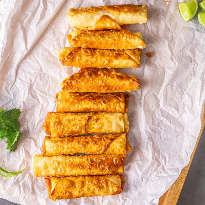 Peruvian Tequeños on parchment paper on a wood tray.
