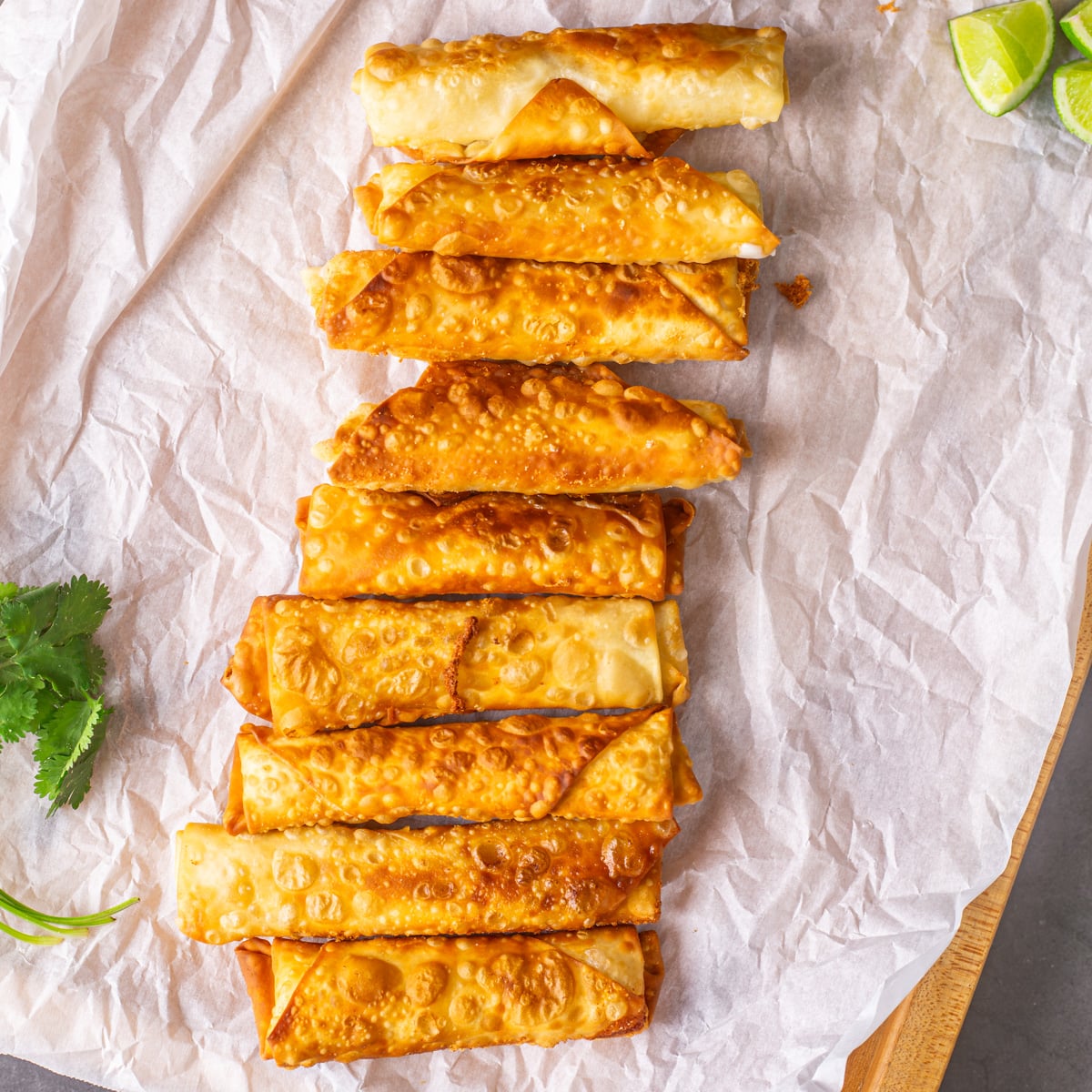 Peruvian Teque&ntilde;os on parchment paper on a wood tray.