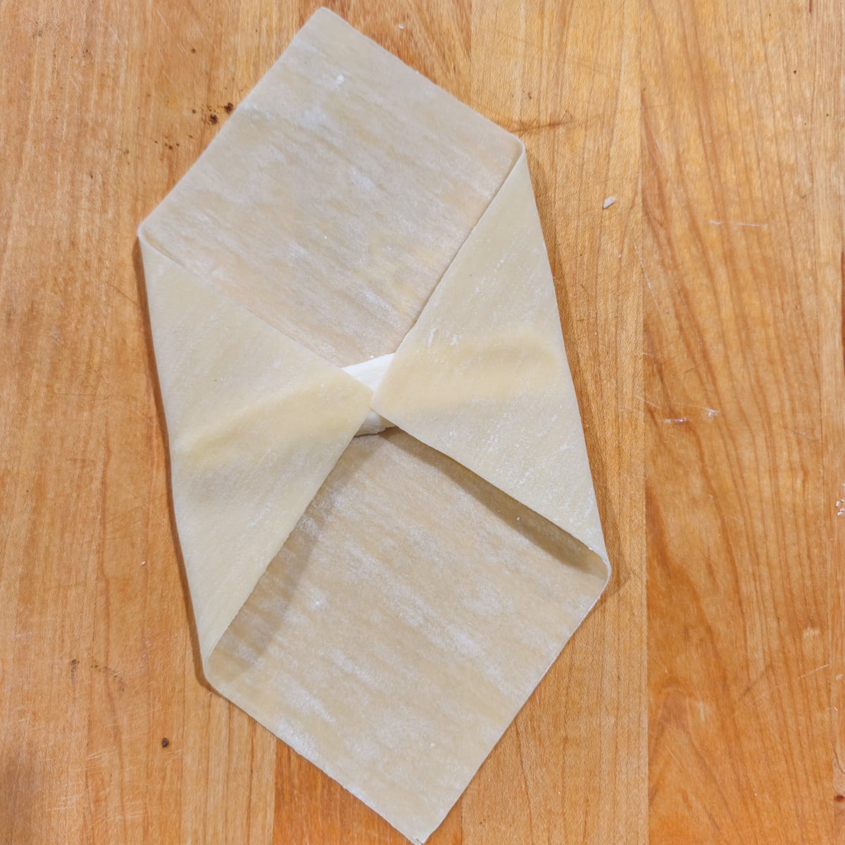 Tequeno in process with cheese partially wrapped.