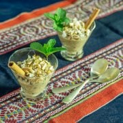 A wool table runner with 2 glass cups of quinoa con leche with cinnamon stick and mint.