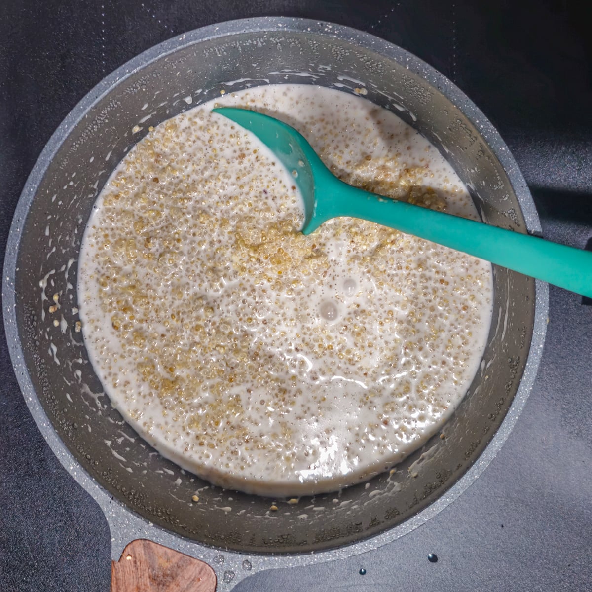 The quinoa is cooked in coconut milk and water in a medium saucepan.