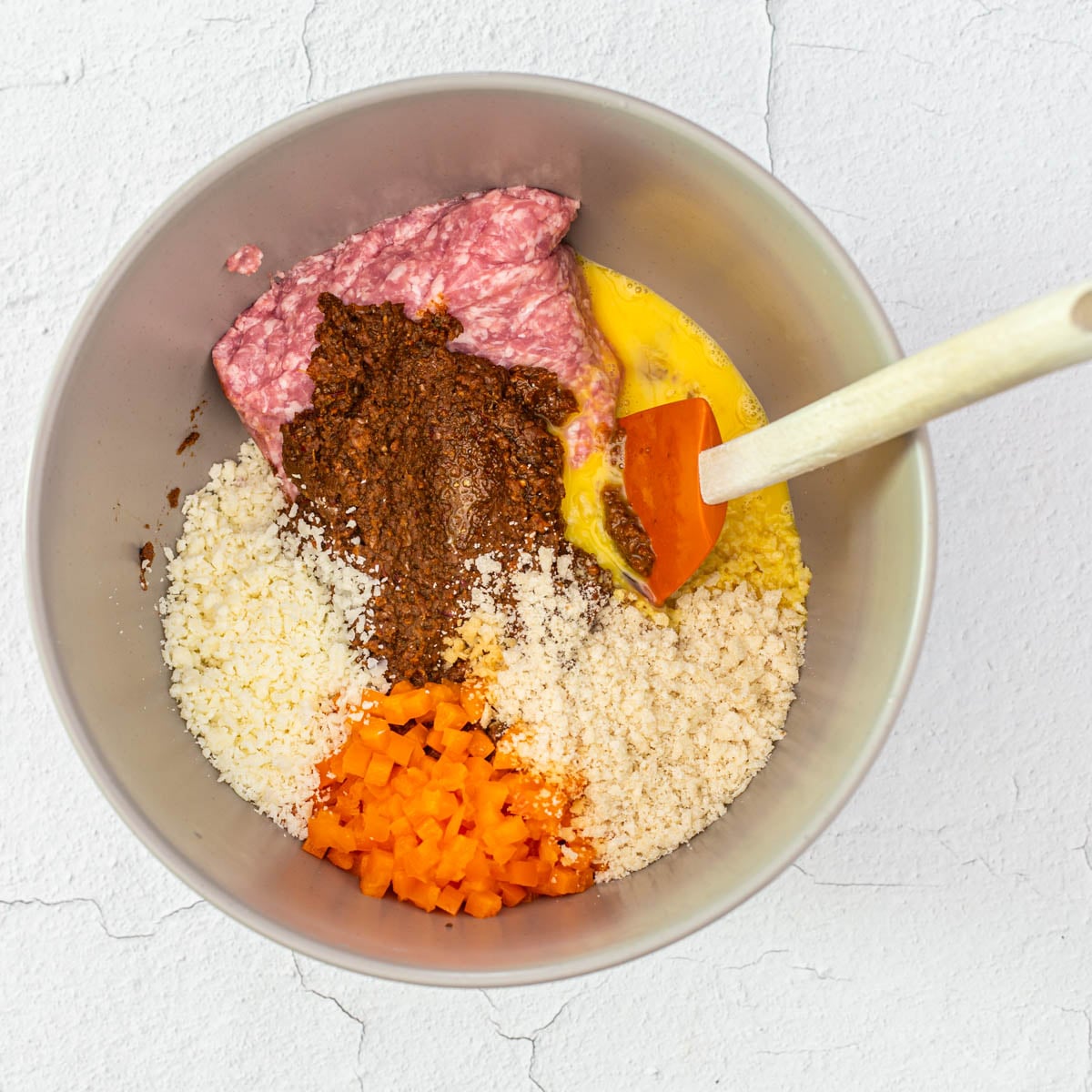 Step 2 - All healthy Mexican meatloaf ingredients are added to a large grey mixing bowl.