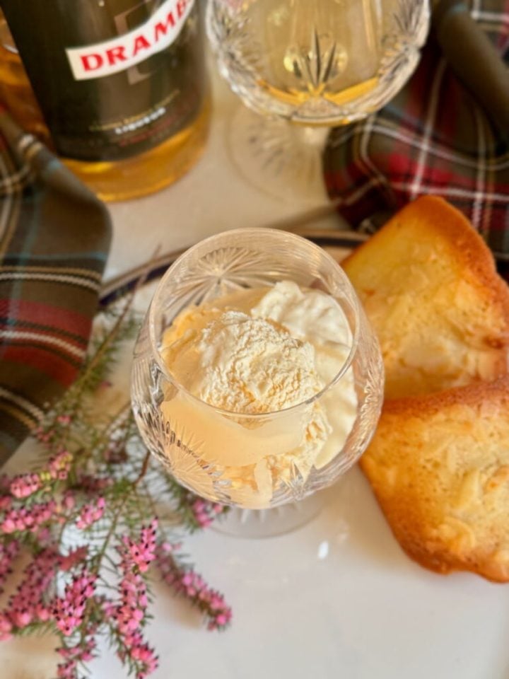 A glass ice cream dish with a scoop of whisky ice cream.