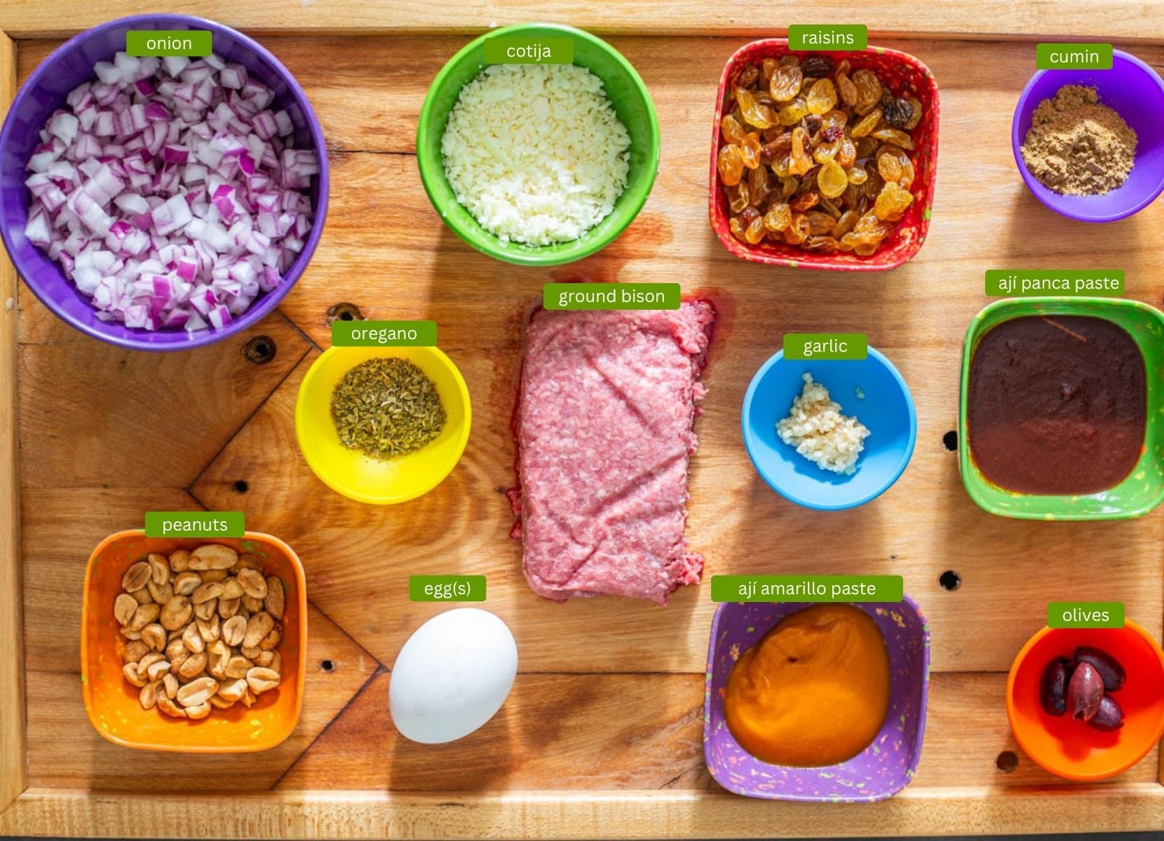 Ingredients for arroz tapado including ground bison, aj&iacute; amarillo and aj&iacute; panca pastes, peanuts and raisins.
