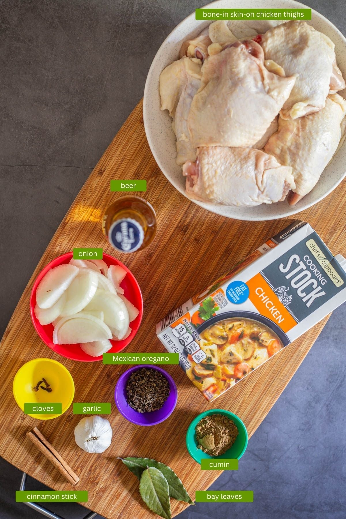 Ingredients for birria de pollo including bone-in skin-on chicken thighs, garlic, onion, and spices.